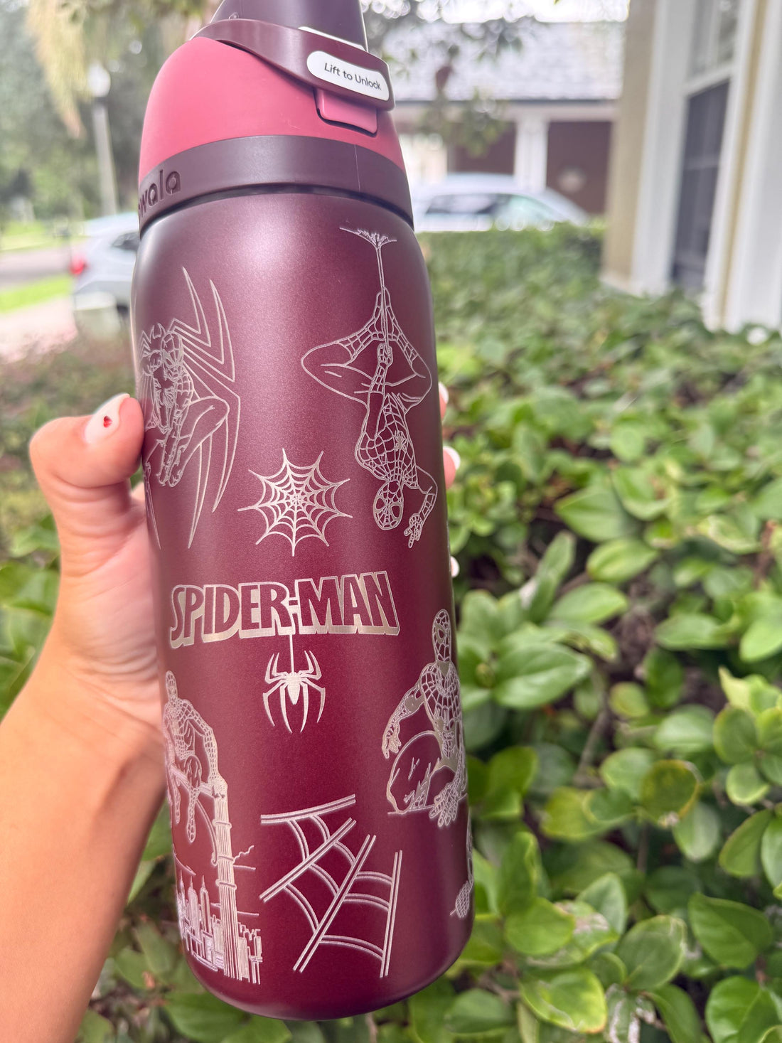 Burgundy Owala FreeSip laser engraved with a Spider-Man design and web pattern
