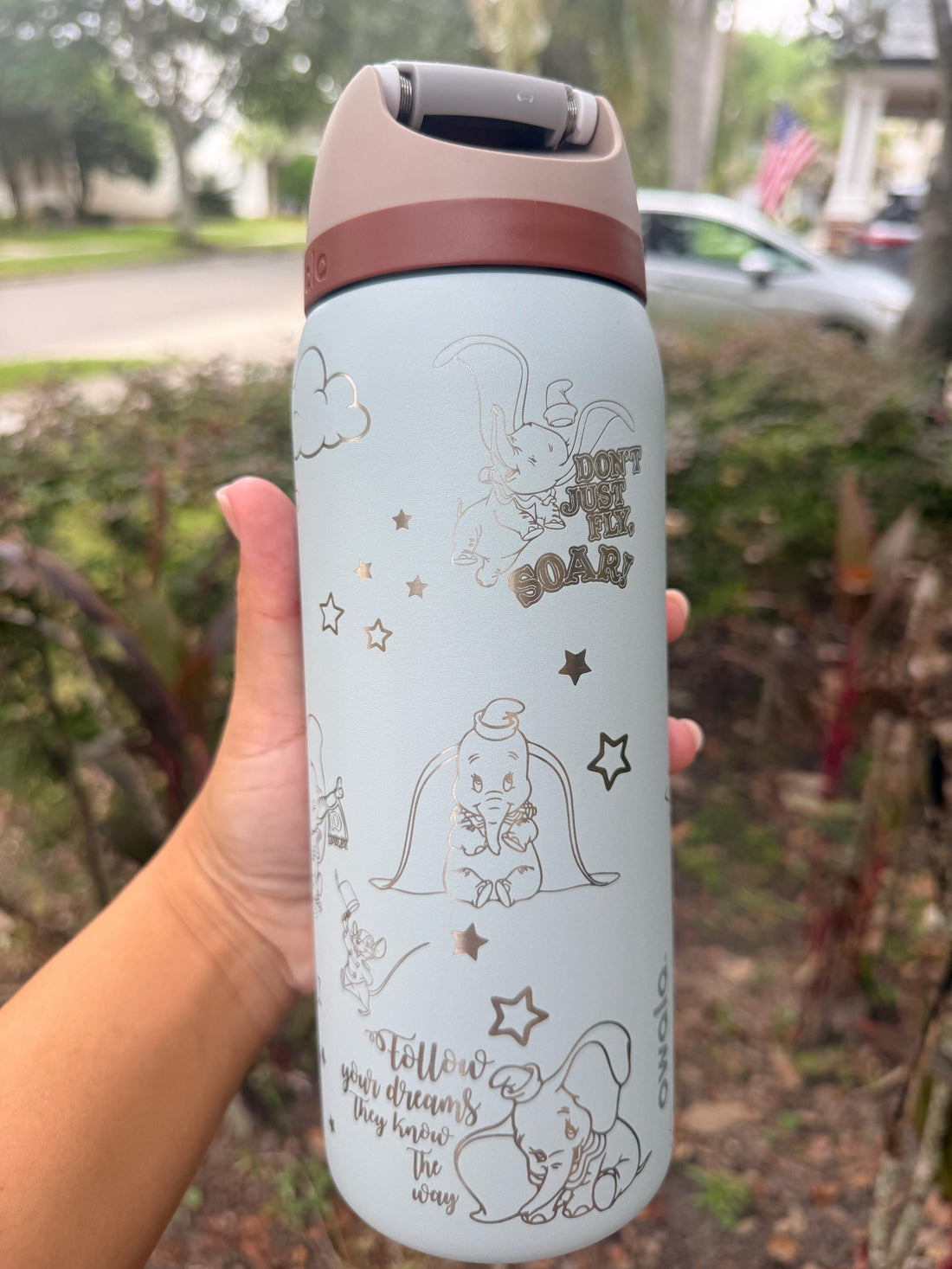Light blue Owala FreeSip laser engraved with a Dumbo-inspired design and a name