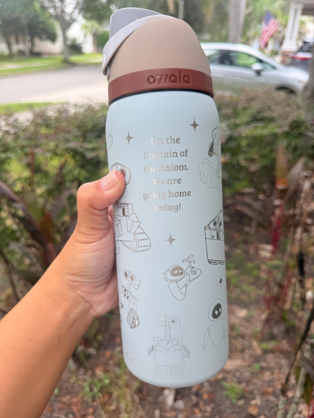 Back of a light blue Owala showing an engraved name and WALL-E artwork