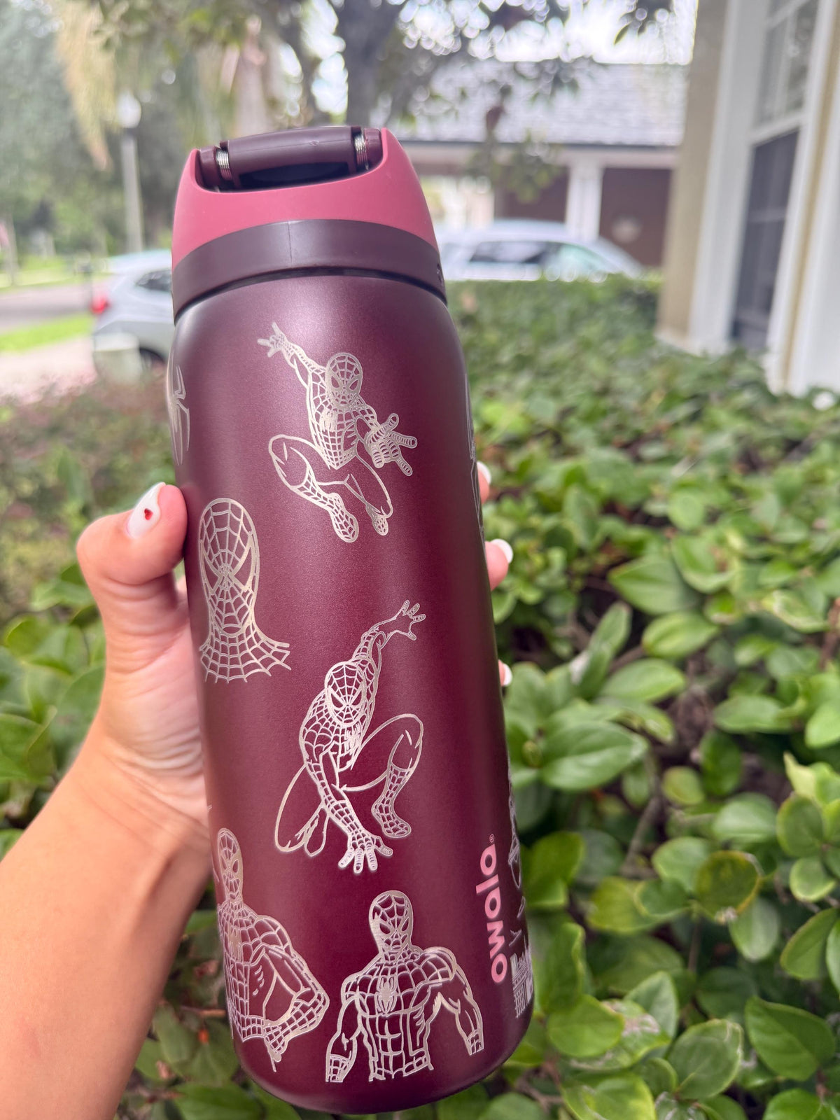 Full view of a burgundy Owala FreeSip with engraved Spider-Man artwork