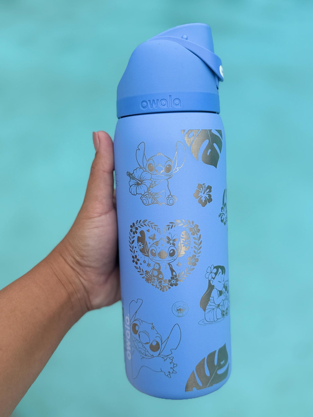 Blue engraved Stitch Owala FreeSip held by a pool