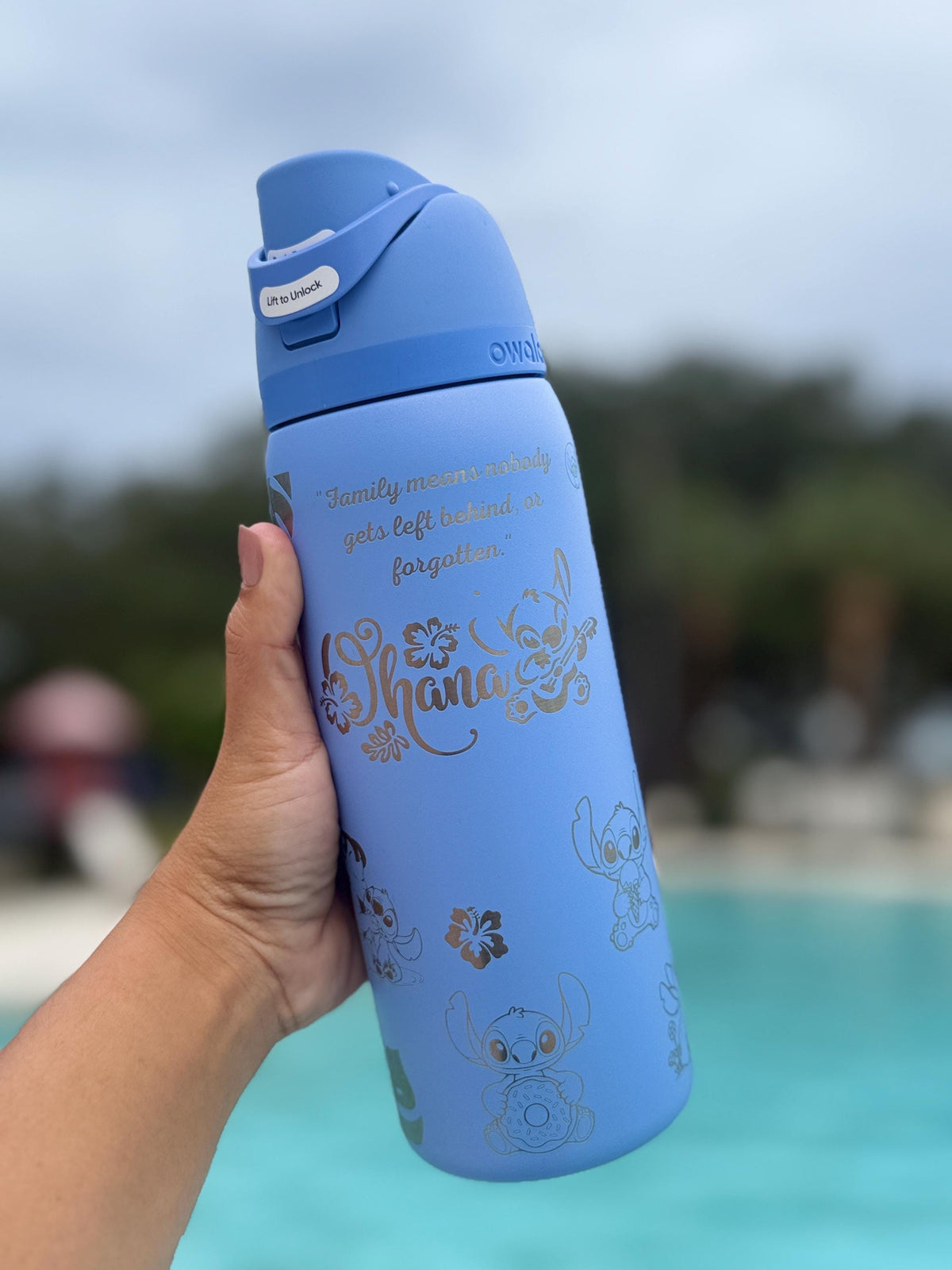 Blue Owala FreeSip laser engraved with a Stitch-inspired design by the pool