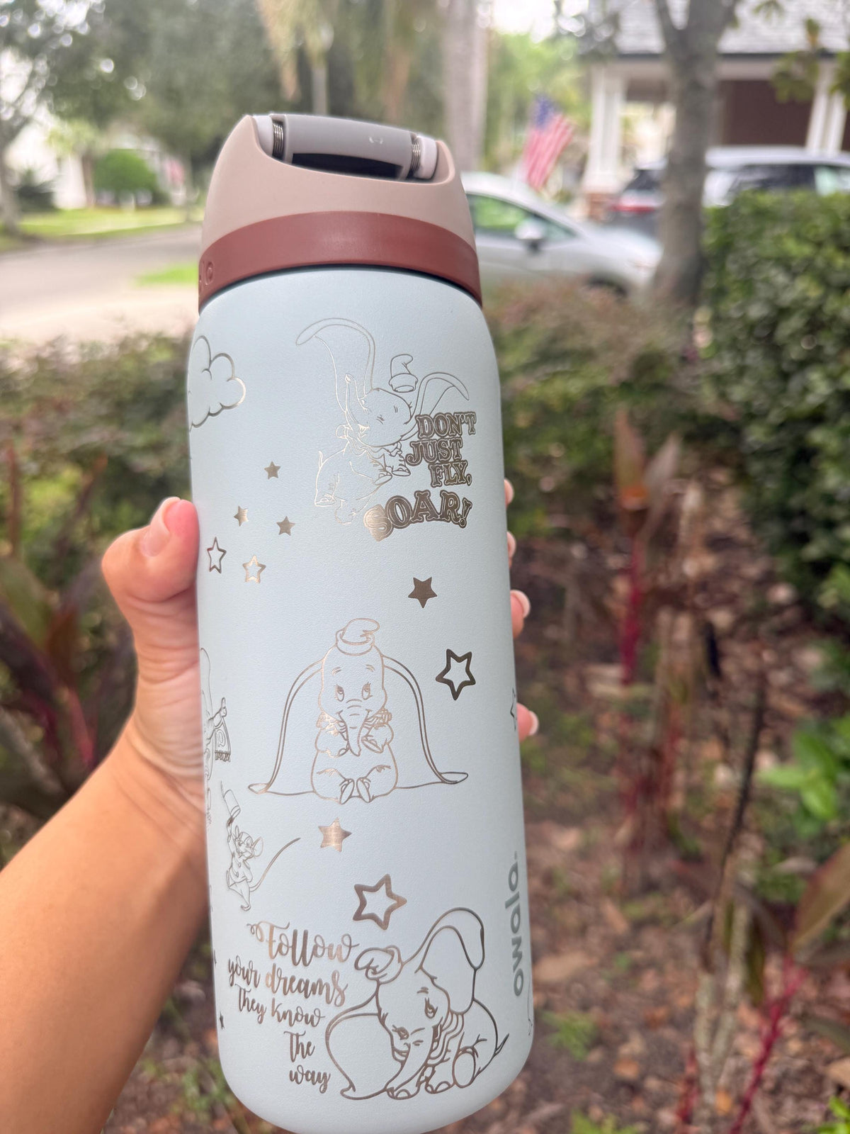 Back of a light blue Owala showing the engraved name and Dumbo design