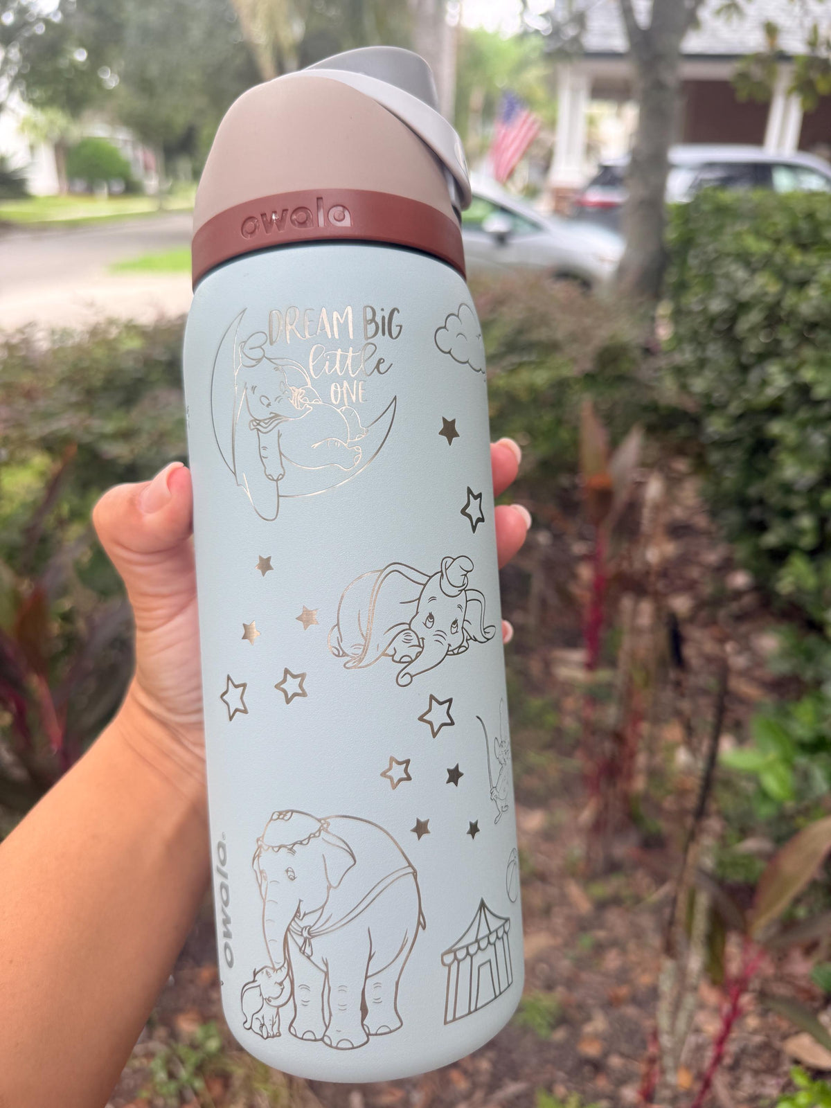 Engraved circus tent and Dumbo artwork on a light blue Owala bottle
