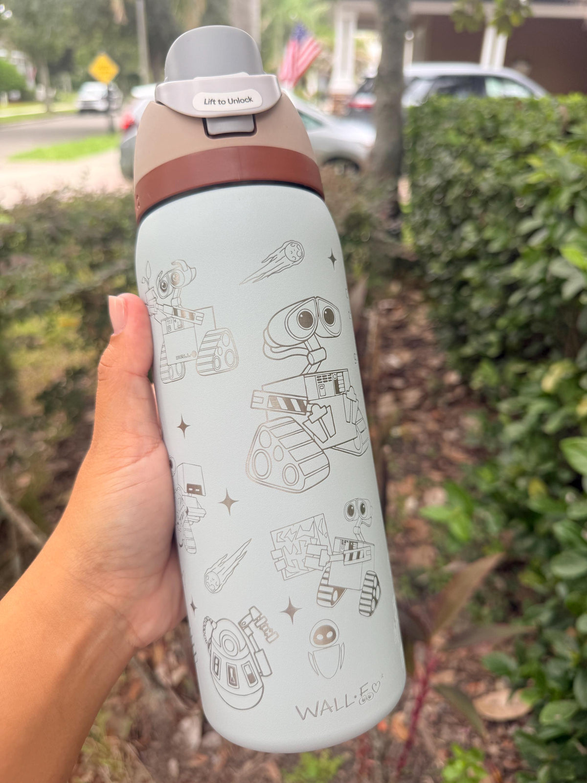 Side view of a light blue Owala with engraved robot artwork