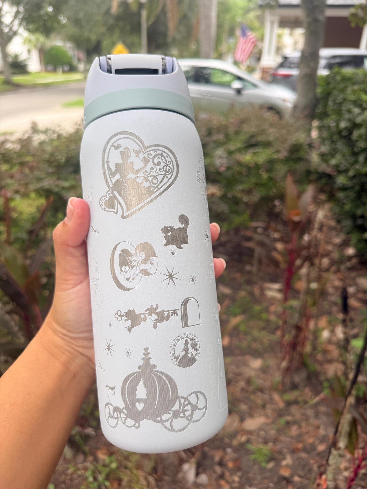 White Owala FreeSip laser engraved with a Cinderella-inspired castle and carriage design