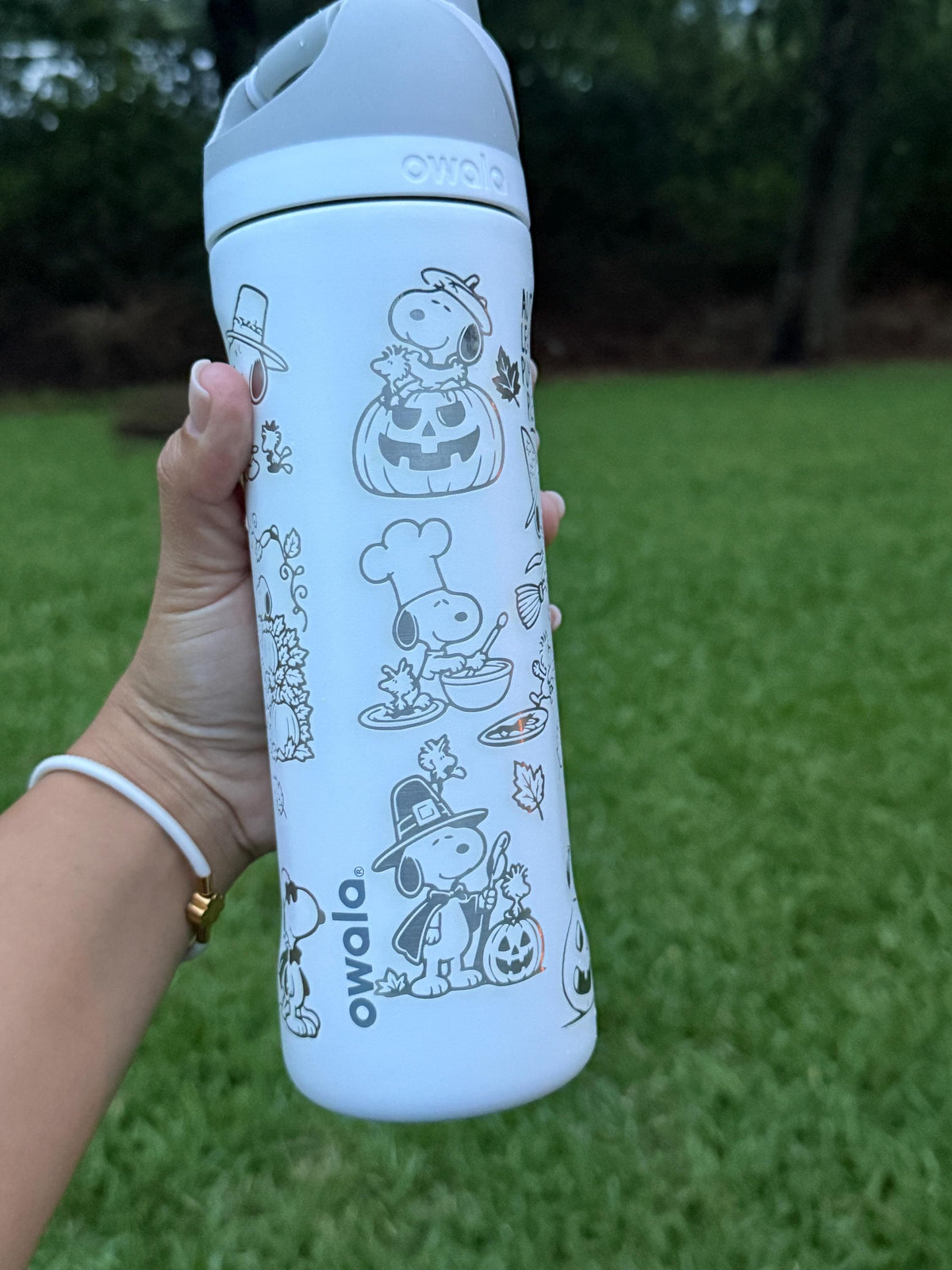 Side view of a light blue Owala with engraved Snoopy fall artwork