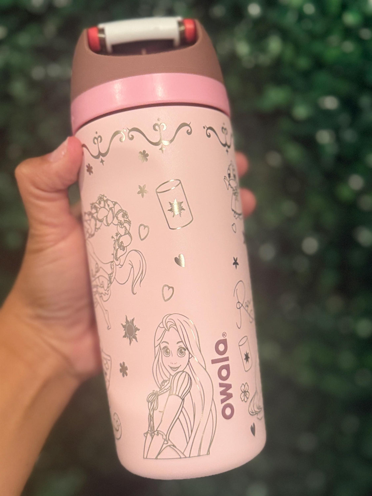 Side view of a pink Owala bottle with engraved Rapunzel artwork