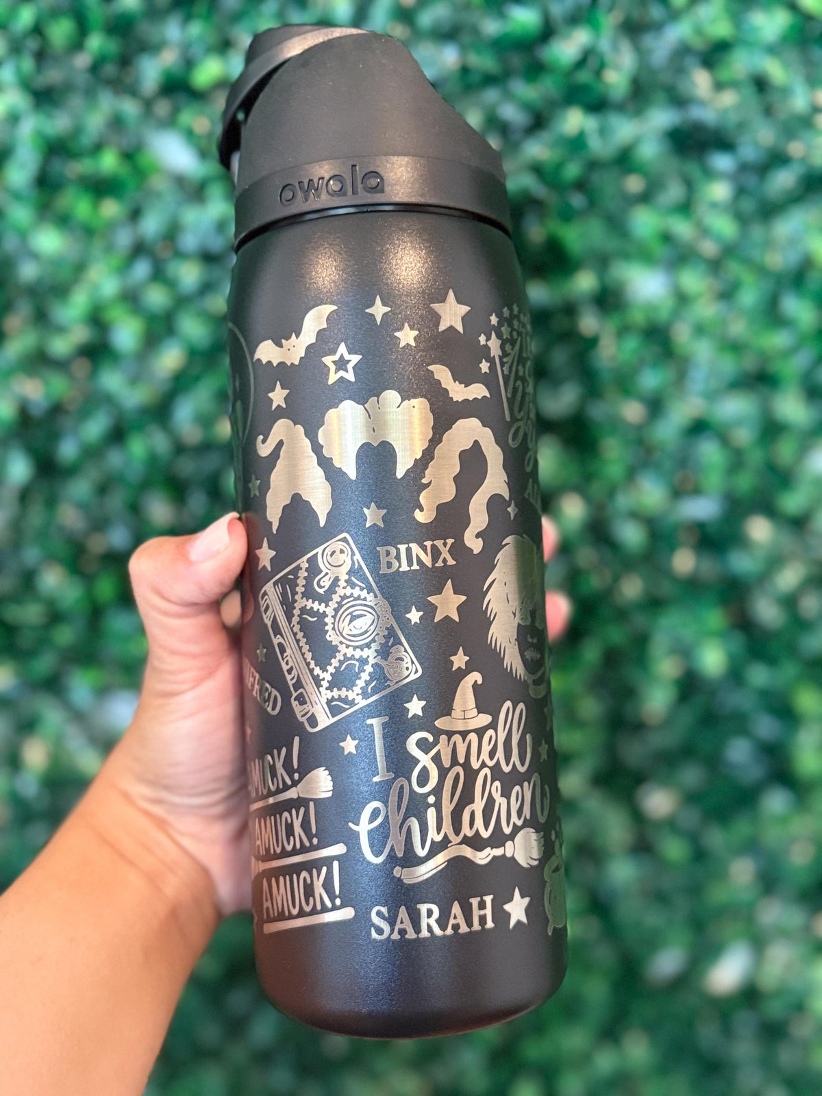 Close-up of witch-themed Halloween engraving on a black Owala FreeSip